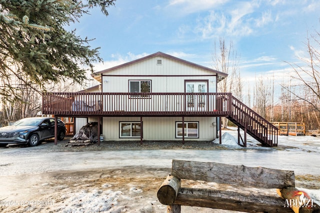 view of front of property featuring stairs, a wooden deck, and driveway