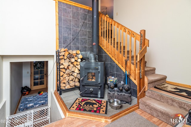 stairs with a wood stove and wood finished floors