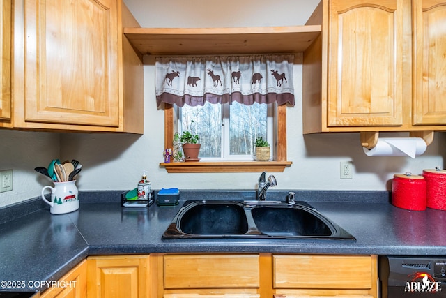 kitchen with a sink, black dishwasher, dark countertops, and light brown cabinetry