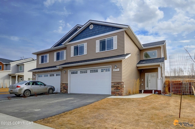 view of front facade featuring stone siding, an attached garage, driveway, and a front yard