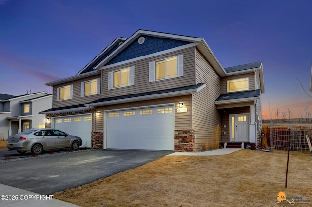 view of front of house featuring aphalt driveway, stone siding, an attached garage, and fence