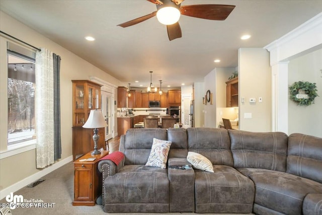 living room featuring visible vents, baseboards, ceiling fan, light carpet, and recessed lighting