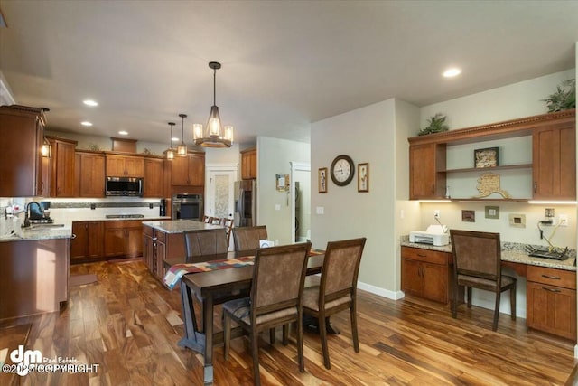 dining area featuring dark wood-style floors, a chandelier, recessed lighting, and baseboards