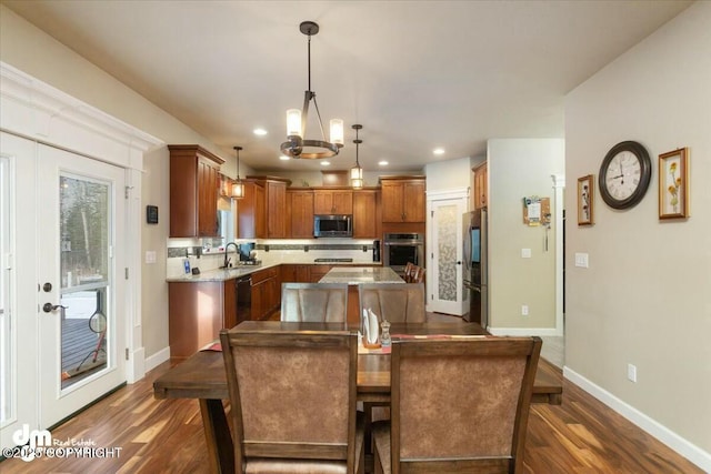 dining room with recessed lighting, baseboards, dark wood-type flooring, and an inviting chandelier