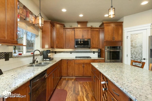 kitchen with a sink, decorative backsplash, appliances with stainless steel finishes, and brown cabinetry