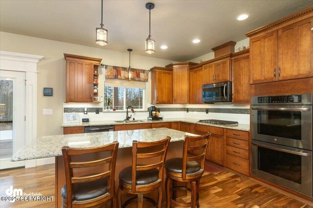 kitchen with decorative backsplash, dark wood-type flooring, appliances with stainless steel finishes, and a sink