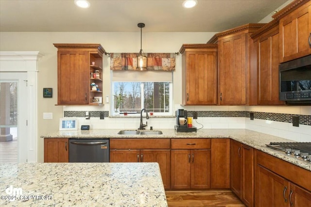 kitchen with a sink, backsplash, stainless steel appliances, light stone countertops, and hanging light fixtures