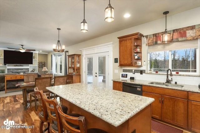 kitchen featuring a sink, tasteful backsplash, black dishwasher, and brown cabinets