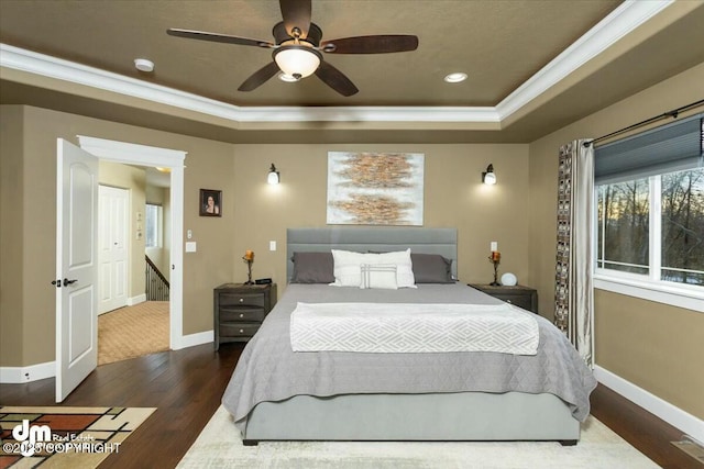 bedroom featuring crown molding, baseboards, a tray ceiling, recessed lighting, and wood finished floors