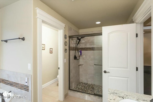 bathroom featuring vanity, toilet, baseboards, and a stall shower