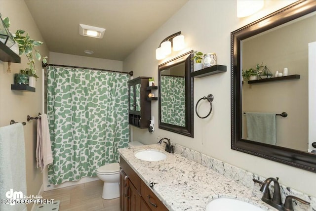 full bath with curtained shower, double vanity, toilet, and a sink