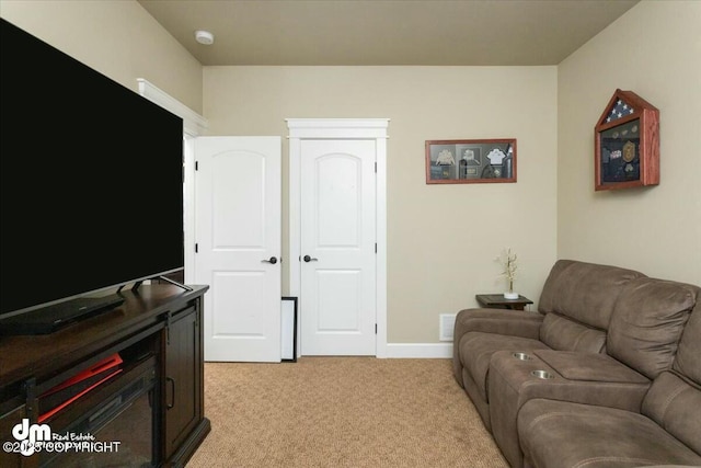 living room with visible vents, light colored carpet, and baseboards