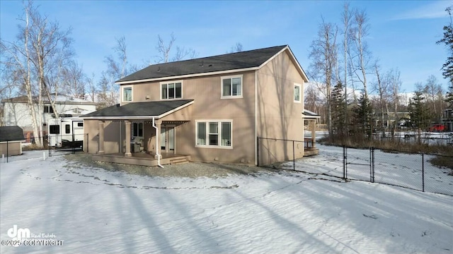 snow covered property with a gate and fence