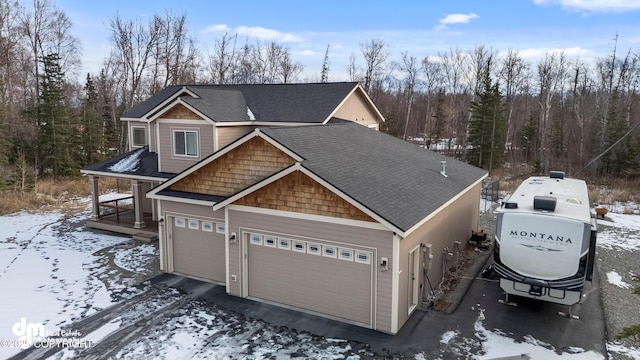 view of front facade featuring an attached garage, driveway, and roof with shingles