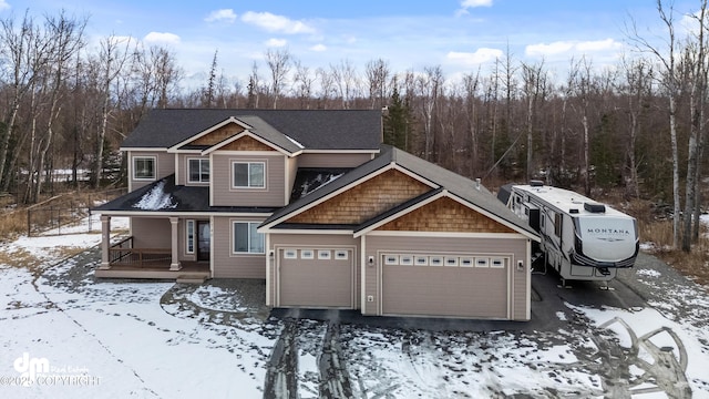 view of front of house with aphalt driveway, covered porch, a shingled roof, and a garage