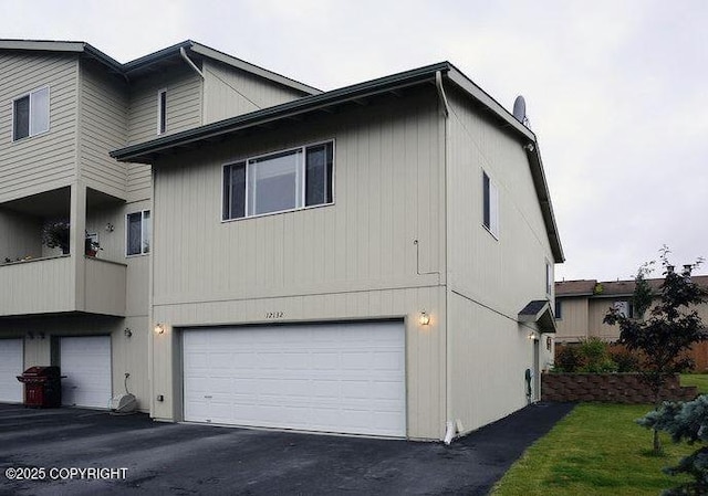 view of side of home with an attached garage and driveway