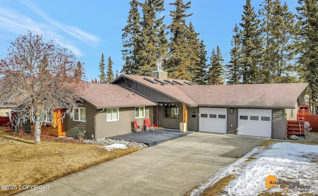 view of front of home featuring an attached garage, driveway, and a shingled roof