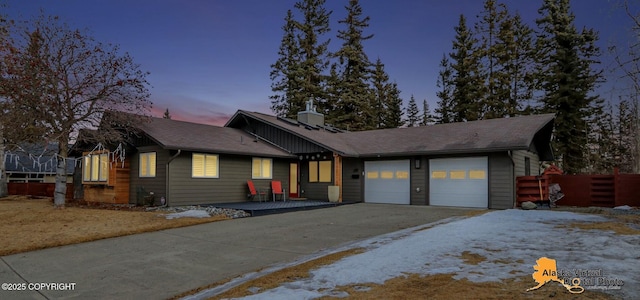 view of front facade featuring an attached garage, fence, and driveway