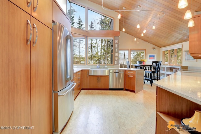 kitchen with a sink, appliances with stainless steel finishes, brown cabinetry, and wood ceiling