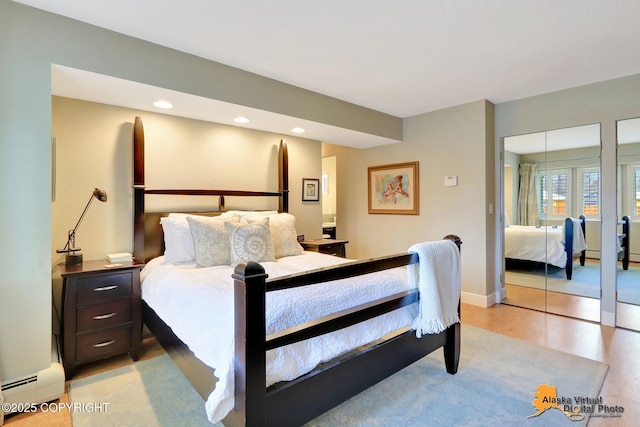 bedroom with baseboards, recessed lighting, light wood-type flooring, and a baseboard radiator