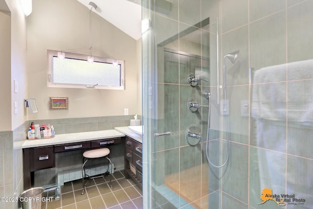 full bath with tile patterned floors, a stall shower, vanity, and vaulted ceiling