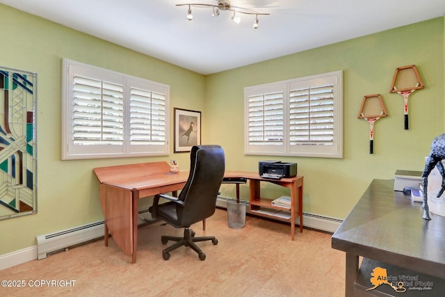 office space featuring a wealth of natural light, a baseboard heating unit, and baseboards