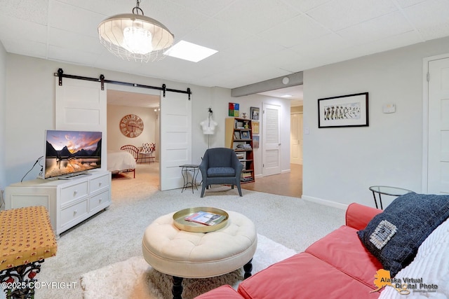 living area with light carpet, baseboards, and a barn door