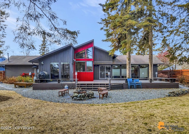 back of house with a wooden deck and a sunroom