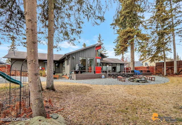 back of property featuring a wooden deck and fence