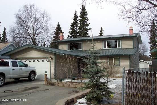 traditional home featuring a garage, driveway, and a chimney