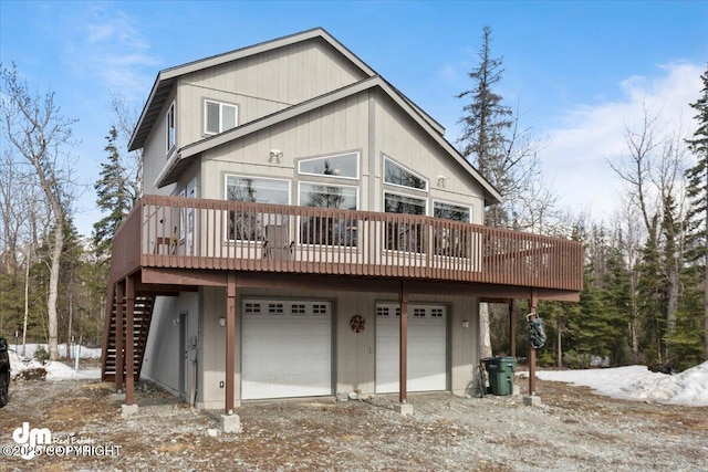 back of house featuring driveway, an attached garage, and stairs