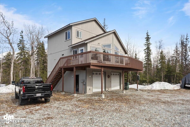 view of front of house featuring stairway, a garage, a deck, and dirt driveway