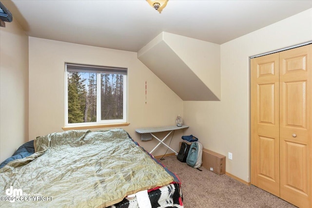 carpeted bedroom featuring a closet and baseboards