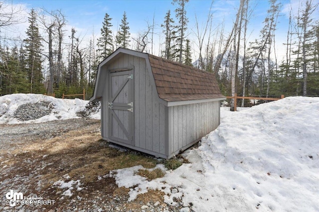 snow covered structure with a storage unit and an outdoor structure