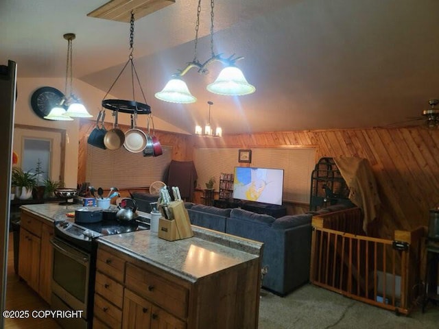 kitchen featuring decorative light fixtures, a kitchen island, wooden walls, stainless steel electric range, and vaulted ceiling