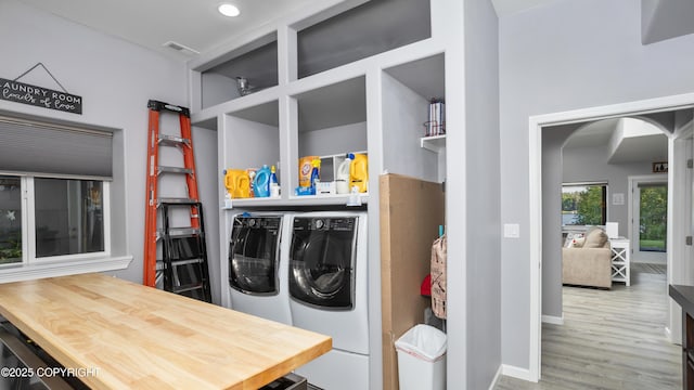 clothes washing area with wood finished floors, visible vents, baseboards, recessed lighting, and independent washer and dryer