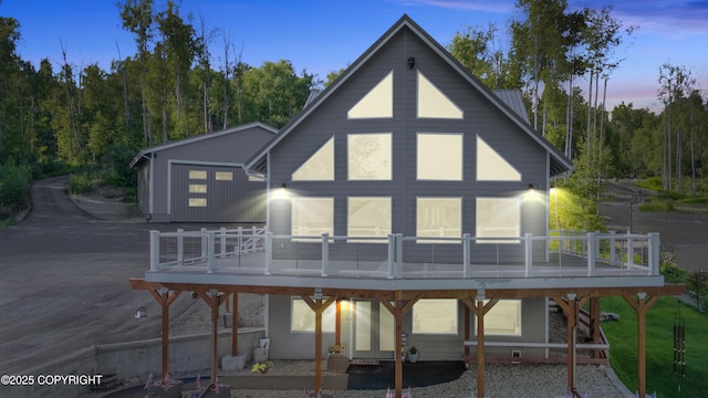 back of house with metal roof and a deck