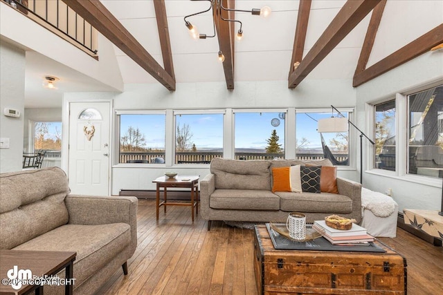 living room with baseboard heating, a healthy amount of sunlight, and hardwood / wood-style floors