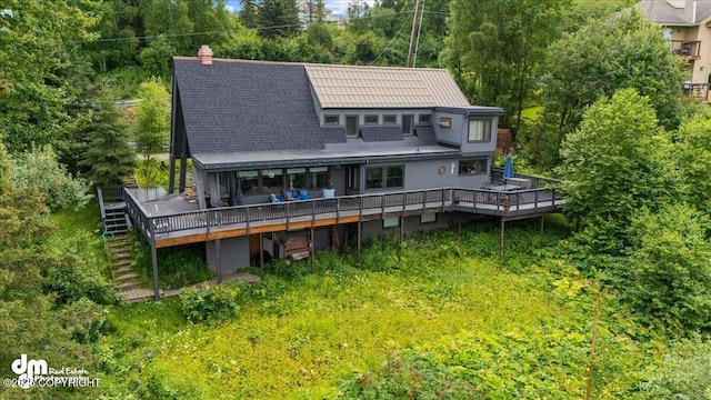 back of house with a chimney, a deck, and stairs