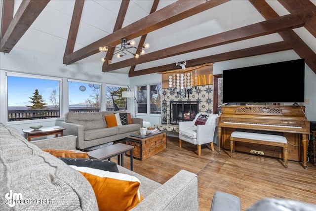 living area featuring beamed ceiling, a tile fireplace, high vaulted ceiling, and wood finished floors