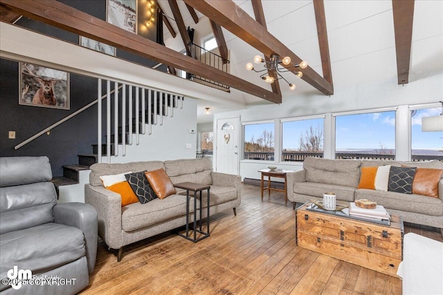 living area featuring stairway, a notable chandelier, beamed ceiling, and high vaulted ceiling