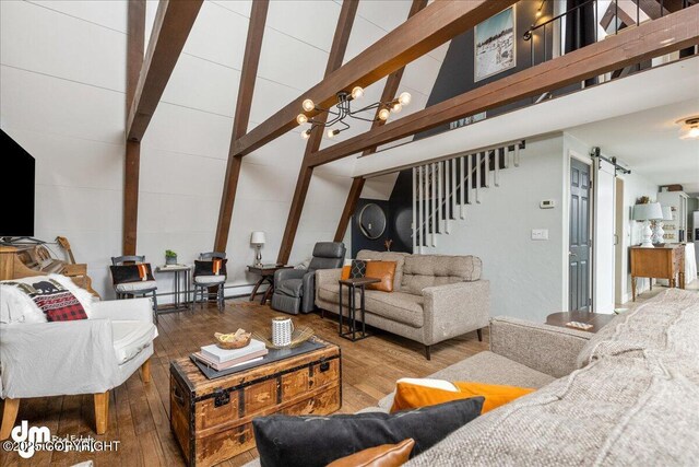 living room with beamed ceiling, stairs, a barn door, wood finished floors, and high vaulted ceiling