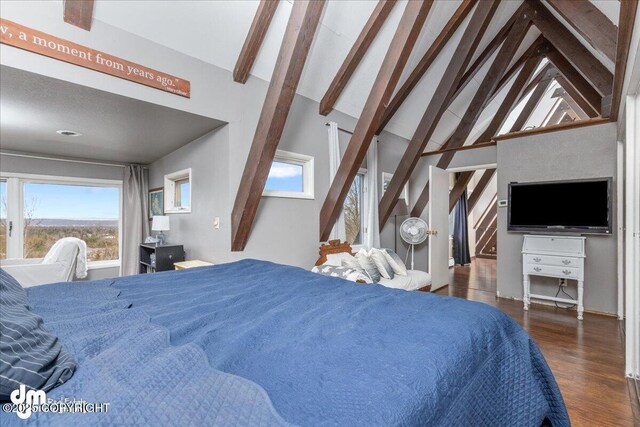 bedroom with vaulted ceiling with beams and wood finished floors