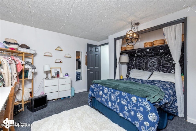 bedroom with an inviting chandelier, carpet flooring, baseboards, and a textured ceiling