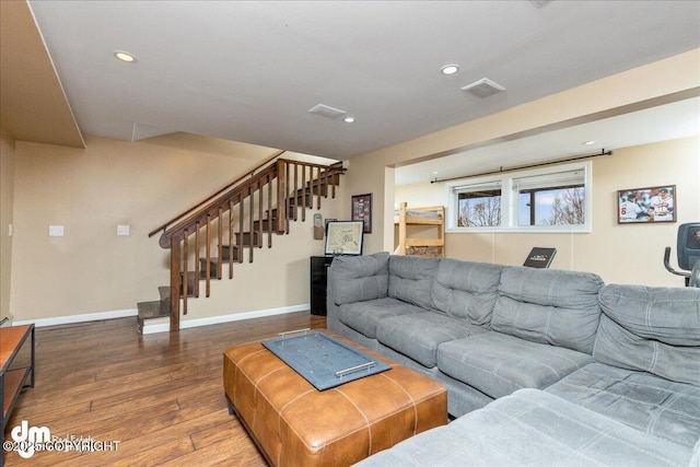 living area with stairs, wood finished floors, visible vents, and baseboards