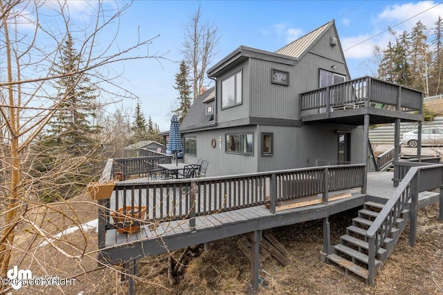 back of property featuring outdoor dining space and a wooden deck