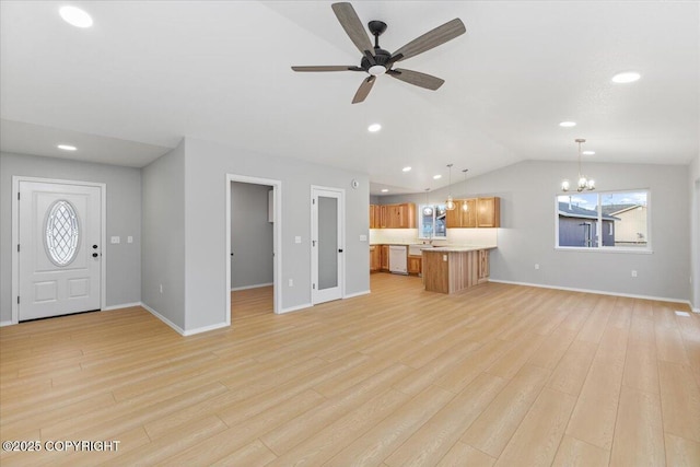 unfurnished living room with baseboards, light wood finished floors, ceiling fan with notable chandelier, and vaulted ceiling