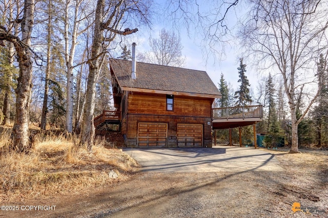 exterior space featuring driveway, an attached garage, and stairs