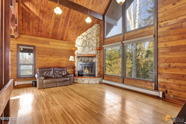 unfurnished living room featuring beam ceiling, a stone fireplace, wood ceiling, wood walls, and a baseboard heating unit