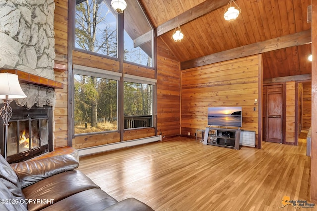 living room featuring beam ceiling, a baseboard heating unit, wood finished floors, wood walls, and a fireplace